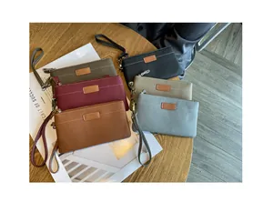 Close-up of genuine leather clutch wallets in multiple colors on a wooden table