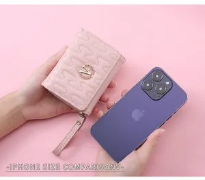 Pink quilted faux leather short wallet for women next to an iPhone for size comparison.