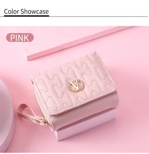 Detailed view of pink women's short wallet with wavy quilted pattern and gold V-logo
