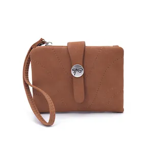 Détail d'un petit porte-monnaie en cuir marron avec coutures et boucle en forme de nœud