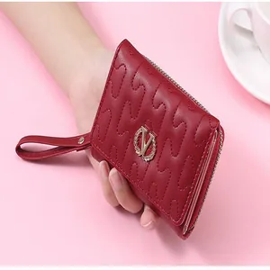 Macro detail of red stitched wallet with wheat wreath V metal logo and wrist strap