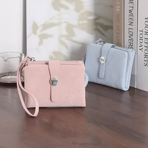 Gros plan de petits portefeuilles élégants en similicuir rose et bleu avec boucle à nœud