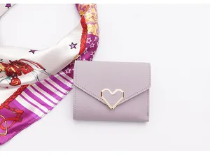 Detailed view of lavender short wallet with a stylish gold heart-shaped metal clasp.