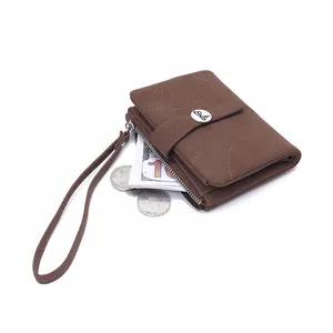 Gros plan d'un petit portefeuille marron pour femme avec boucle papillon et dragonne