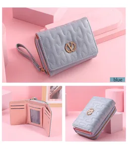 Multi-angle view of light blue quilted folding wallet with gold V logo and wrist strap.