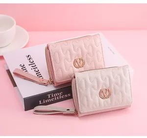 Detailed view of two quilted short wallets with wavy stitching and gold wheat ear V-logo