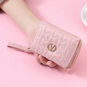 Elegant pink women's short wallet featuring wave stitching and a gold V logo with wristlet strap