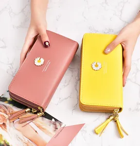 Detailed view of pink and yellow long wallets with daisy accents and stylish tassels.