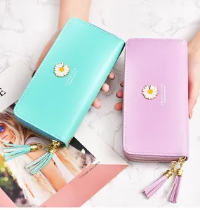 Close-up view of elegant double zipper ladies long wallets with daisy accent and tassels.