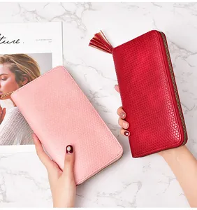 Close-up detail showing the woven texture of women's long wallet with a stylish tassel