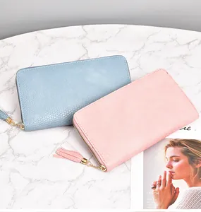 Detail view of pink and blue woven long wallets with tassel zipper charms