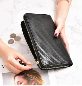 Detailed view of a black woven pattern long wallet with gold zipper and a tassel
