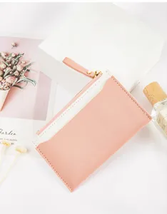Close-up view of a pink and white PU leather zipper card holder with stitching details