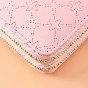 High-quality close-up of pink embossed women's long wallet with double gold zippers