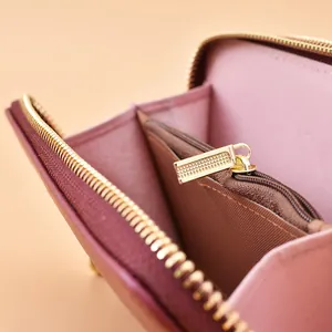 Vista interna dettagliata di un portafoglio lungo rosa con doppia cerniera e hardware in metallo