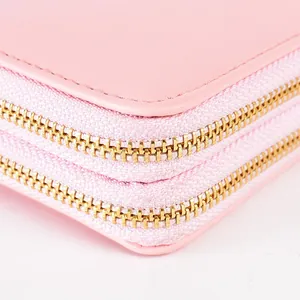 Close-up view of an elegant pink long wallet with durable double golden metal zippers