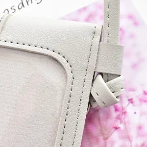 Gros plan d'un sac à bandoulière gris minimaliste pour téléphone à écran tactile