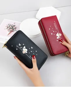 Detail of women's long double zipper wallets with heart print and bird pattern