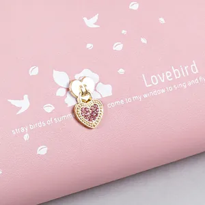 Elegant long pink wallet for women featuring a sparkling heart charm and bird prints