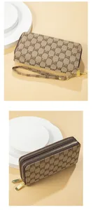 Close-up detail of women's long double-zipper clutch bag with chic monogram pattern