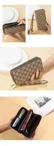 Detail view of brown monogram long clutch wallet with double zippers and wrist strap