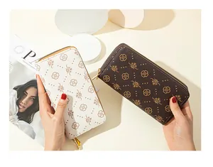 Detailed view of two double-zipper floral print long wallets in white and brown.