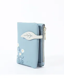 Detailed view of light blue soft leather wallet featuring delicate daisy floral print.
