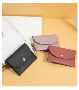 Vista dettagliata di tre mini portamonete in pelle nei colori nero, viola e rosso.