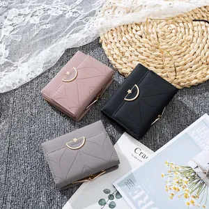Detalle de carteras triples de colores con cierres metálicos florales y costuras