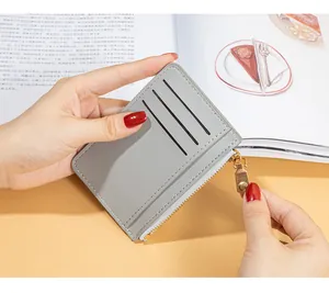 Close-up of grey leather card holder with gold zipper detail and multi-card slots