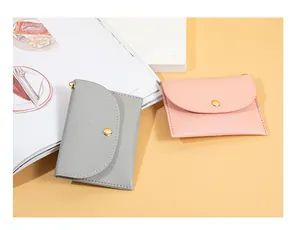 Vista dettagliata di mini portamonete minimalisti in grigio e rosa con chiusura a pressione.
