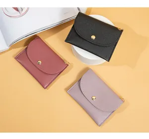 Dettaglio dei mini portamonete da donna in tre colori con chiusura a bottone dorato