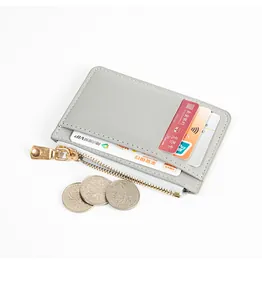 Detail of a slim grey card holder with multiple slots and a zipper compartment for coins.