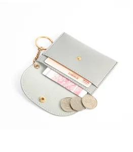 Dettaglio del mini porta carte grigio con la chiusura a scatto e un portachiavi