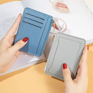 Slim faux leather women's card holder and coin purse set in blue and grey with zipper.