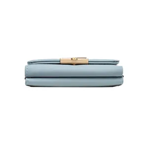 Vista lateral de una cartera pequeña azul claro para mujer con broche dorado