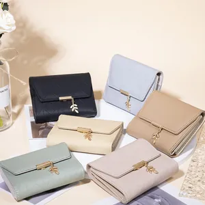 Detail view of quilted trifold wallets for women with gold leaf pendant in six colors
