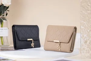 Quilted trifold wallets in black and beige with elegant gold leaf pendant detail.