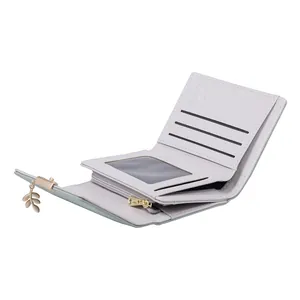 Detailed view showing the interior layout of a trifold wallet with leaf charm decoration.