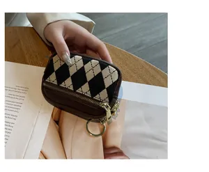 Detailansicht der Mini-Münztasche mit Rautenmuster, Goldreißverschluss und Anhänger