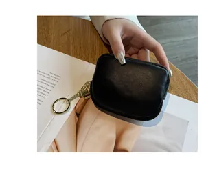 Nahaufnahme einer kompakten schwarzen Leder-Geldbörse mit schickem goldenem Schlüsselring.