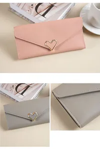 Dettaglio di portafogli lunghi con chiusura a cuore in rosa e grigio e cuciture.