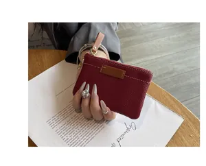 Détail du petit porte-monnaie en cuir rouge montrant sa texture premium et sa taille compacte