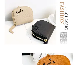 Close-up of cute cat-shaped coin purse with tail zipper pull and lychee grain texture.