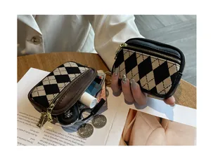 Nahaufnahme der Mini-Münztasche mit Karomuster und Details zum Reißverschluss-Design