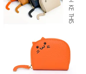 Close-up of a cute orange cat-shaped coin purse with embroidered face and tail zipper detail