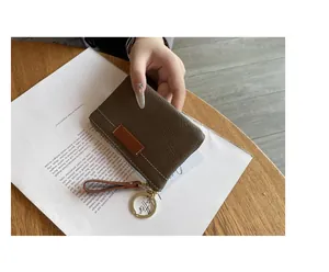 Gros plan sur un mini porte-monnaie en cuir avec porte-clés et dragonne élégante
