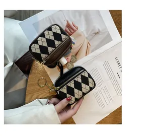 Detailansicht der stylischen Mini-Münztasche mit Rautenmuster, Gold-Reißverschluss und Ring