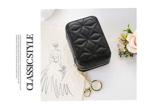 Black quilted cosmetic pouch with gold-tone zipper and functional keychain attachment.