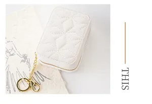 Detailed view of the star-patterned quilted white portable lipstick bag with gold chain